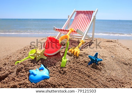 Beach chair near the ocean with plastic toys on sunny day