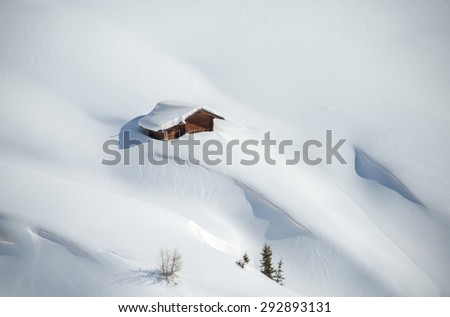Small wooden cabin embedded in snow