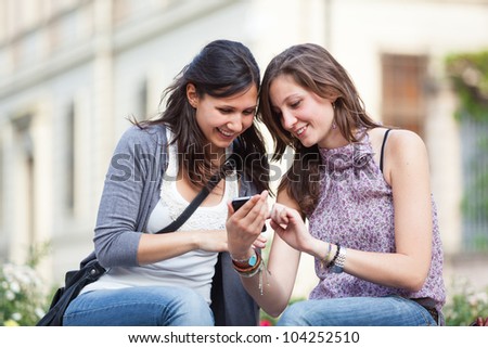 Two Beautiful Women Sending Messages with Mobile Two Beautiful Women Sending Messages with Mobile