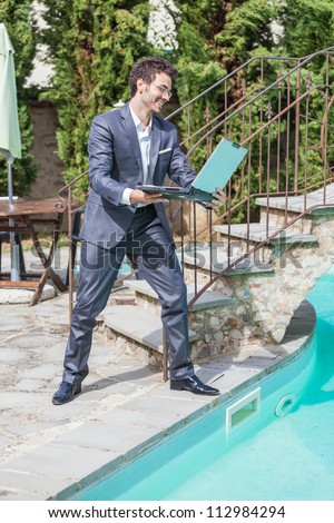 Angry Businessman with Computer next to Swimming Pool