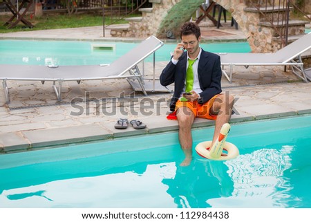 Funny Young Businessman with SwimmingTrunks next to the Pool
