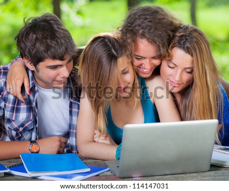 Group of Teenage Students at Park with Computer and Books