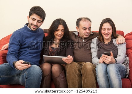 Happy Family on the Sofa with Electonic Devices