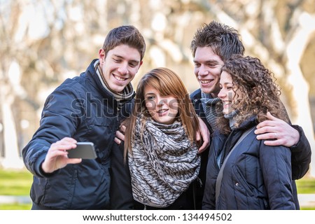 Group of Friends taking Self Portraits with Mobile Phone