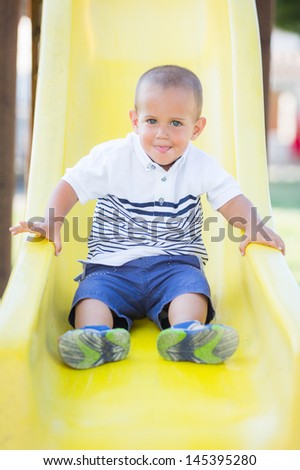 Little Boy Playing on the Slide at Park