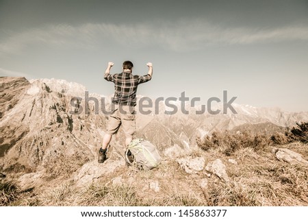 Happy Young Man at Top of the Mountain