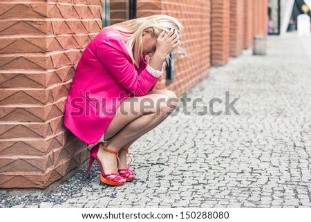 Depressed Woman Against Wall in the City