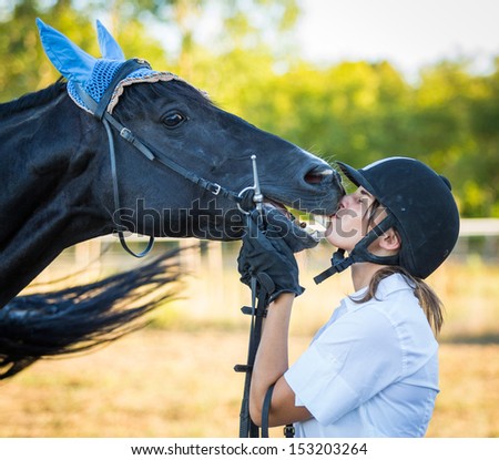 Young Woman Kissing a Black Stallion Horse