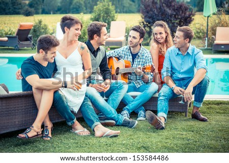 Group Of Friend Singing Together Next To Swimming Pool
