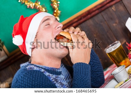 Young Man Eating Hamburger on Christmas Day
