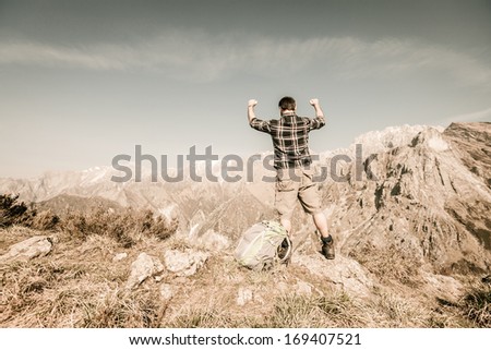Happy Young Man at Top of the Mountain