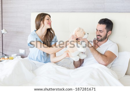 Couple on Bed with Stuffed Animal Toy