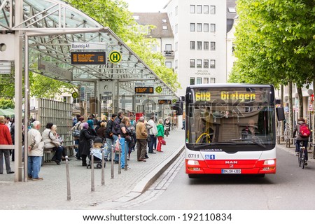 BONN, GERMANY - MAY 6, 2014: People waiting for the bus at bus stop in Friedensplatz