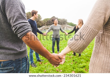 Multiethnic Group of Friends Holding Hands in a Circle