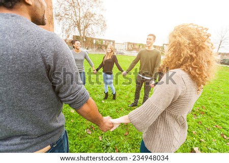 Multiethnic Group of Friends Holding Hands in a Circle