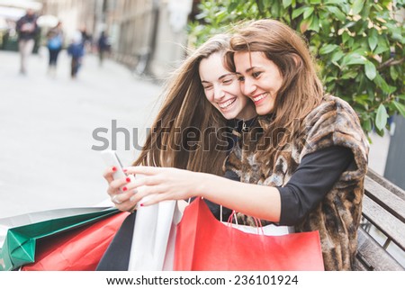 Happy Women with Smart Phone and Shopping Bags