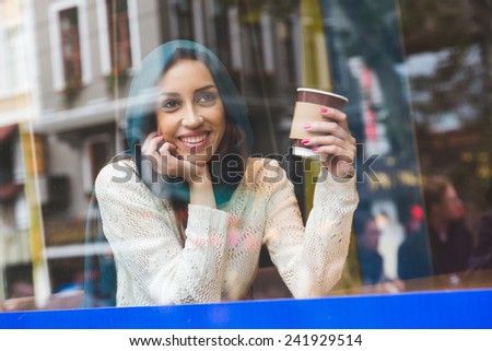Muslim Woman Talking on Mobile Phone in a Cafe