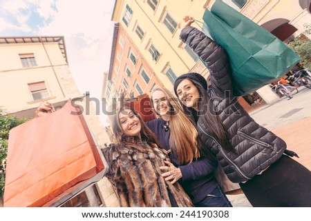 Happy Women with Shopping Bags in the City. Each one is Holding at least a bag and they are really happy about their purchases