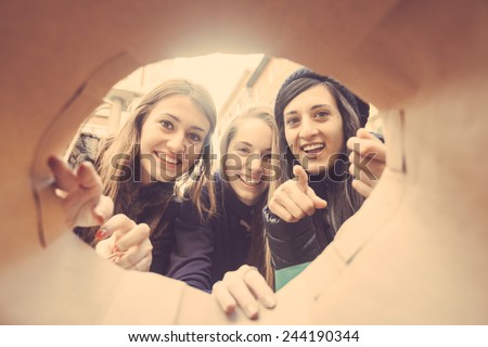 Happy Women Looking into Shopping Bag. The point of view is inside the Bag and Women are Really Curious to See What\'s Inside