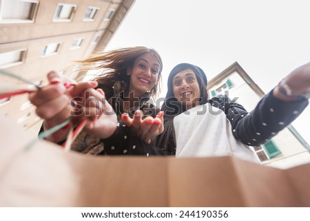 Happy Women Looking into Shopping Bag. The point of view is inside the Bag and Women are Really Curious to See What\'s Inside