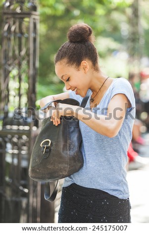 Beautiful Mixed-Race Young Woman Looking Inside Her Bag