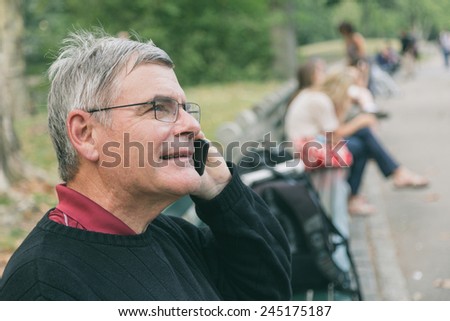 Retired Senior Man at Park, Talking on Mobile, Smiling Expression