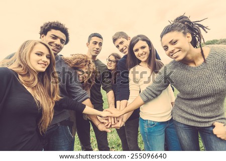 Multiracial group of friends with hands in stack, strong concept about teamwork and cooperation, also refers to immigration and friendship.