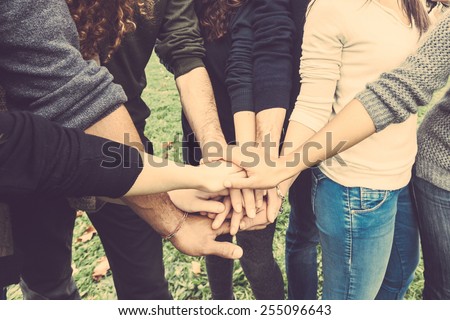 Multiracial group of friends with hands in stack, strong concept about teamwork and cooperation, also refers to immigration and friendship.