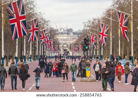 LONDON, UNITED KINGDOM - MARCH 8, 2015: The Mall road with many big United Kingdom flags, also known as Union Jack. Some tourists are walking on the street.