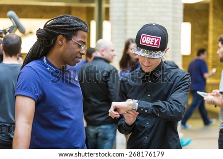 LONDON, UK - APRIL 10, 2015: Customers looking at and wearing brand new Apple Watches at Covent Garden Apple store.