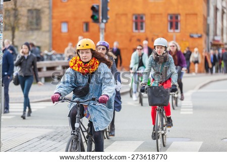 COPENHAGEN, DENMARK - APRIL 28, 2015: People going by bike in the city. A lot of commuters, students and tourists prefer using bike instead of car or bus to move around the city.
