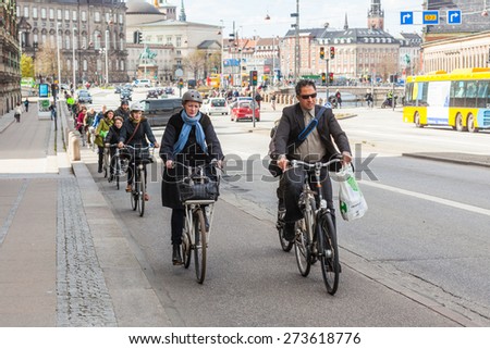 COPENHAGEN, DENMARK - APRIL 28, 2015: People going by bike in the city. A lot of commuters, students and tourists prefer using bike instead of car or bus to move around the city.