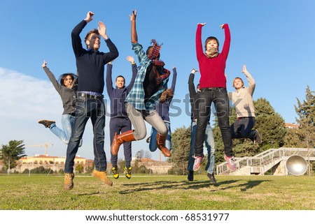 Group of Happy College Students Jumping at Park