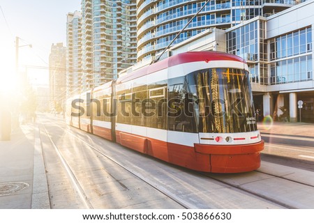 Modern tram in Toronto downtown at sunset. There is no traffic in the road, and nobody on the platform. Travel and transportation concepts.
