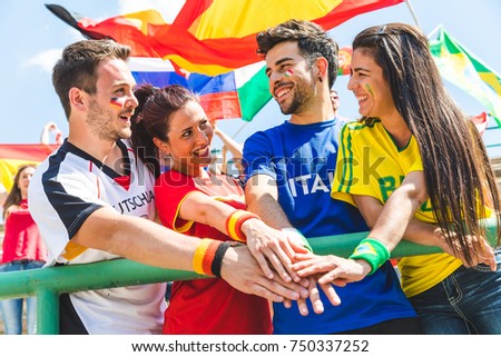 Happy supporters from different countries together at stadium. Fans from Italy, Germany, Spain, Brazil and other countries enjoying a match together. Sport, respect and fair play concepts