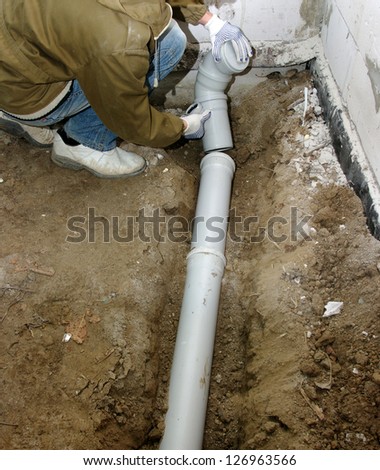 Plumber assembling pvc sewage pipes
