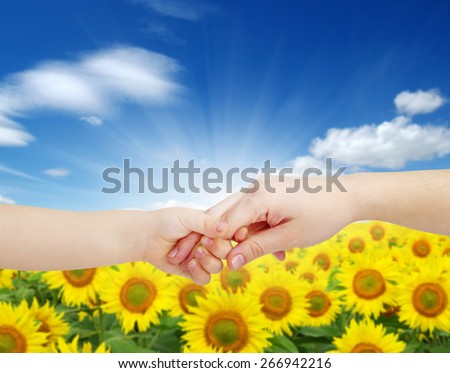 mother gives a hand of a child on landscape