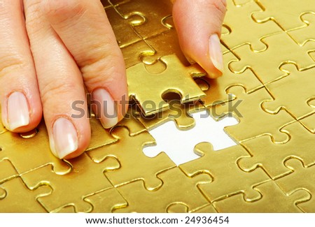 woman fingers holdings gold pazles