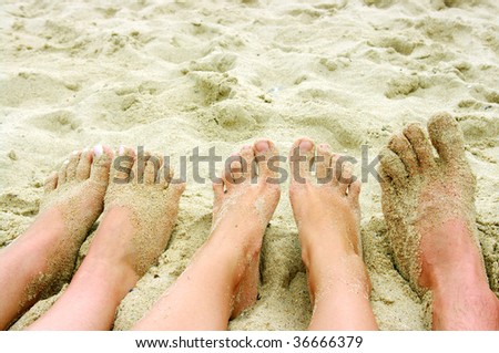 feet of people on a sandy beach