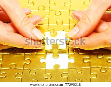 woman fingers holdings gold puzzle