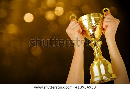Man holding a champion golden trophy