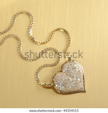 Diamond Heart pendant necklace on heavy gold chain on gold background