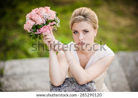 Smiling beautiful bride on your wedding day with a big bouquet