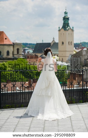 Young bride with bouquet before the wedding ceremony, medieval castle