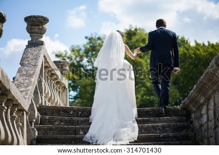 Beautiful bride in wedding dress preparing to ceremony in church. Walking near old castle