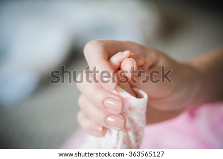 mother holding newborn hands