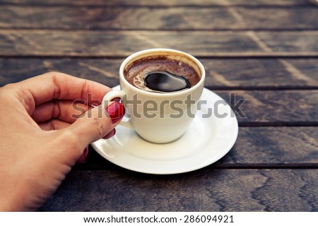 woman\'s hand holding a cup of Turkish coffee \