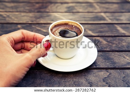 woman\'s hand keeping white cup of Turkish coffee \