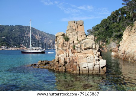 Sea landscape with a rock and small yacht