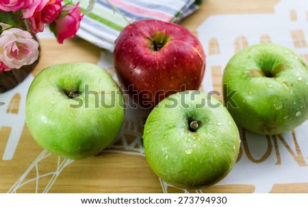 Four apples, red and green on the table